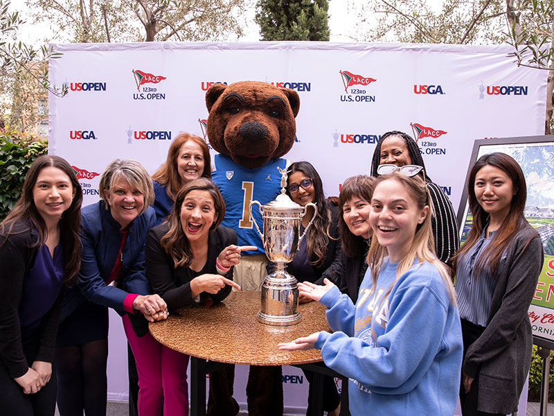 Members of UCLA Hospitality celebrate a photo op with the USGA Trophy